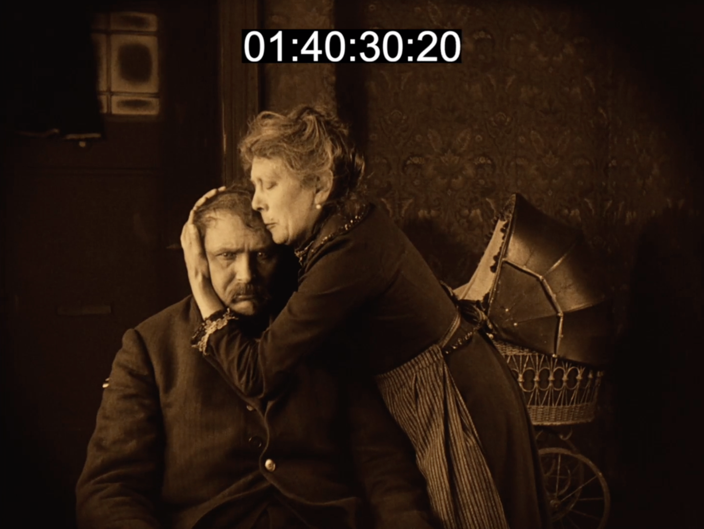 Film still from Sylvester: a woman cradles a man's head against her chest as he sits slumped, echoing the Ghosts embrace.