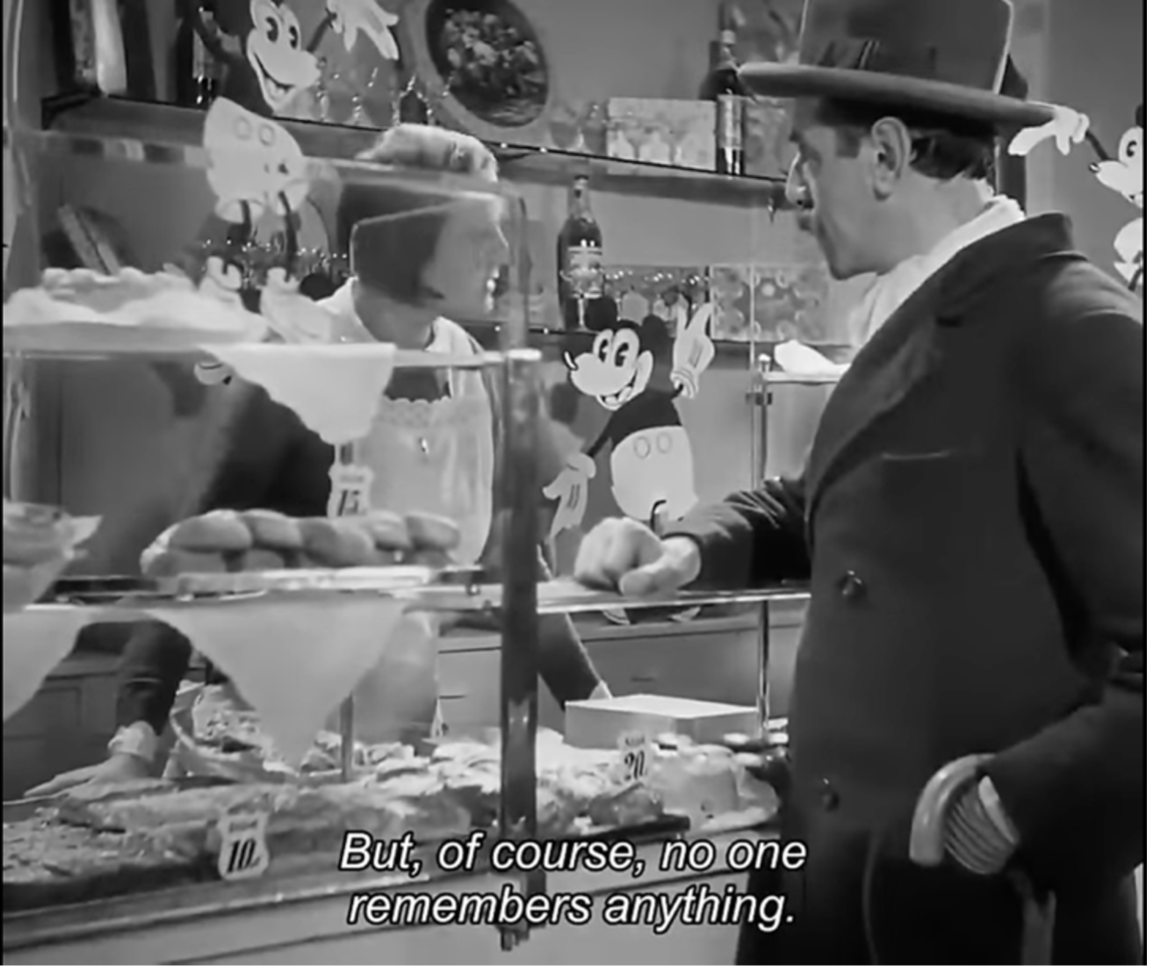 Film still from M: a detective questions a woman behind a candy-store counter decorated with Mickey Mouse cutouts; subtitle reads "But, of course, no one remembers anything."